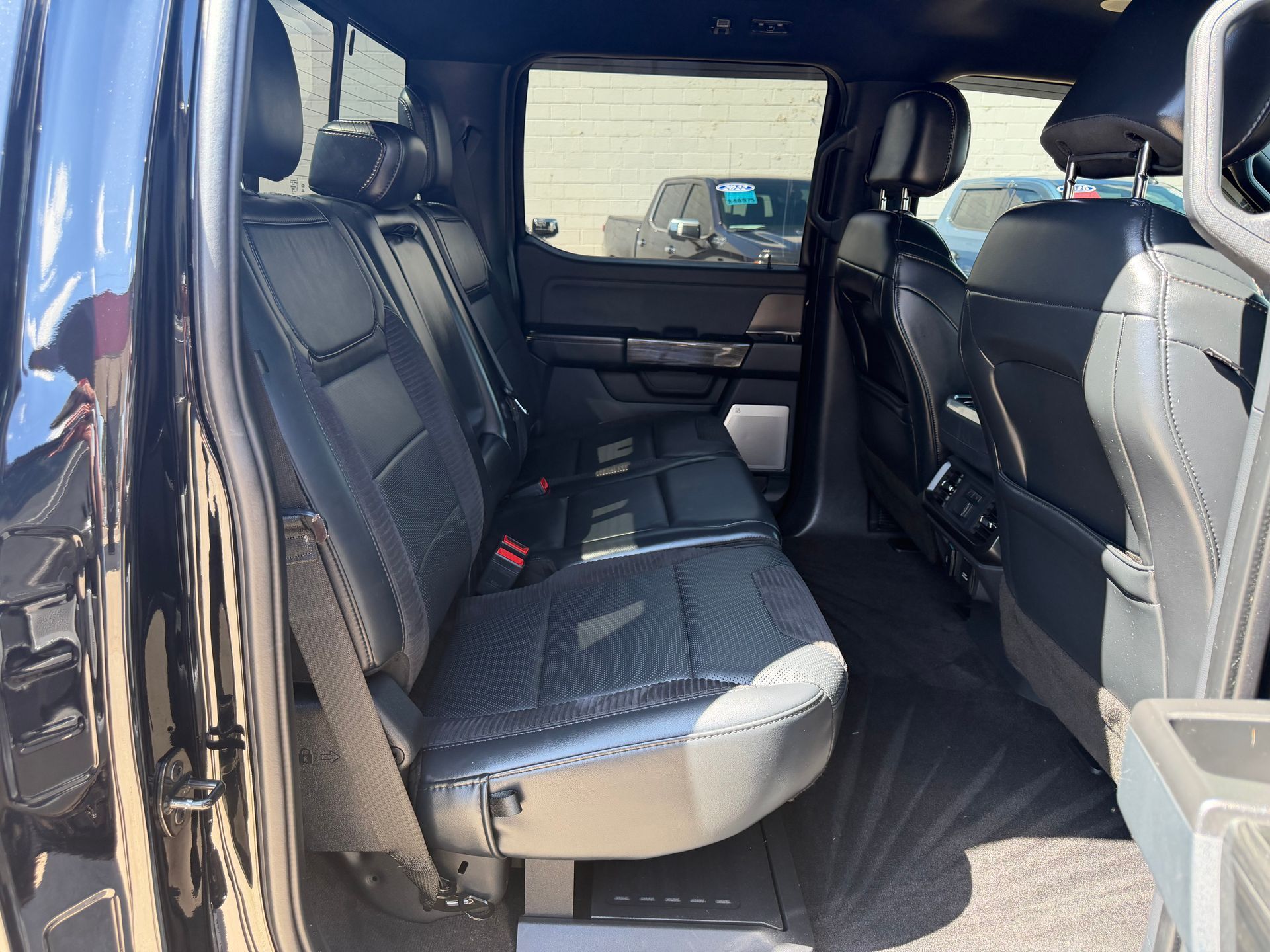 Interior of a black SUV with folded seats, showing a spacious cargo area and rear passenger space