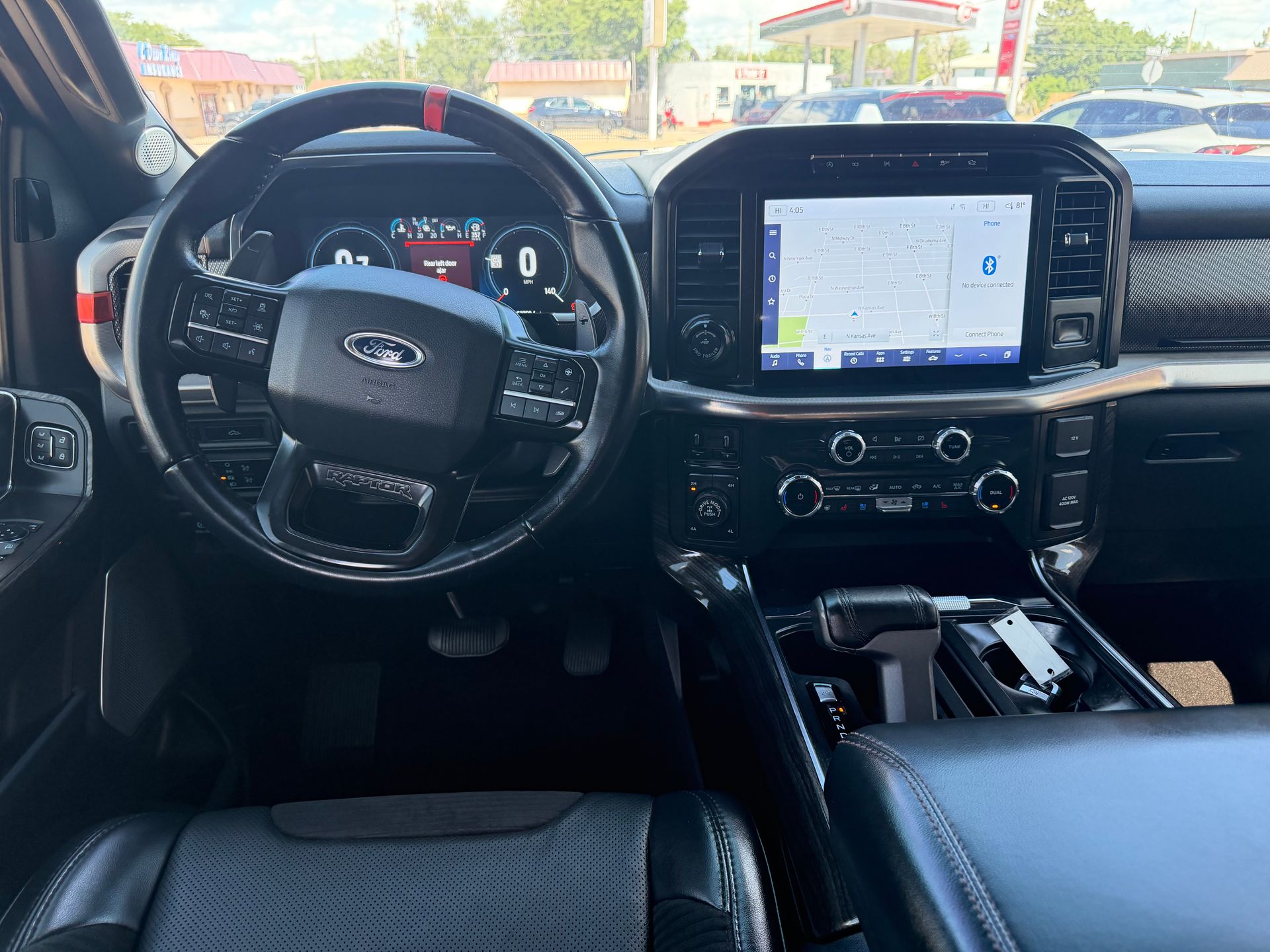 Interior of a Toyota truck, showing the steering wheel, dashboard, and center touchscreen.