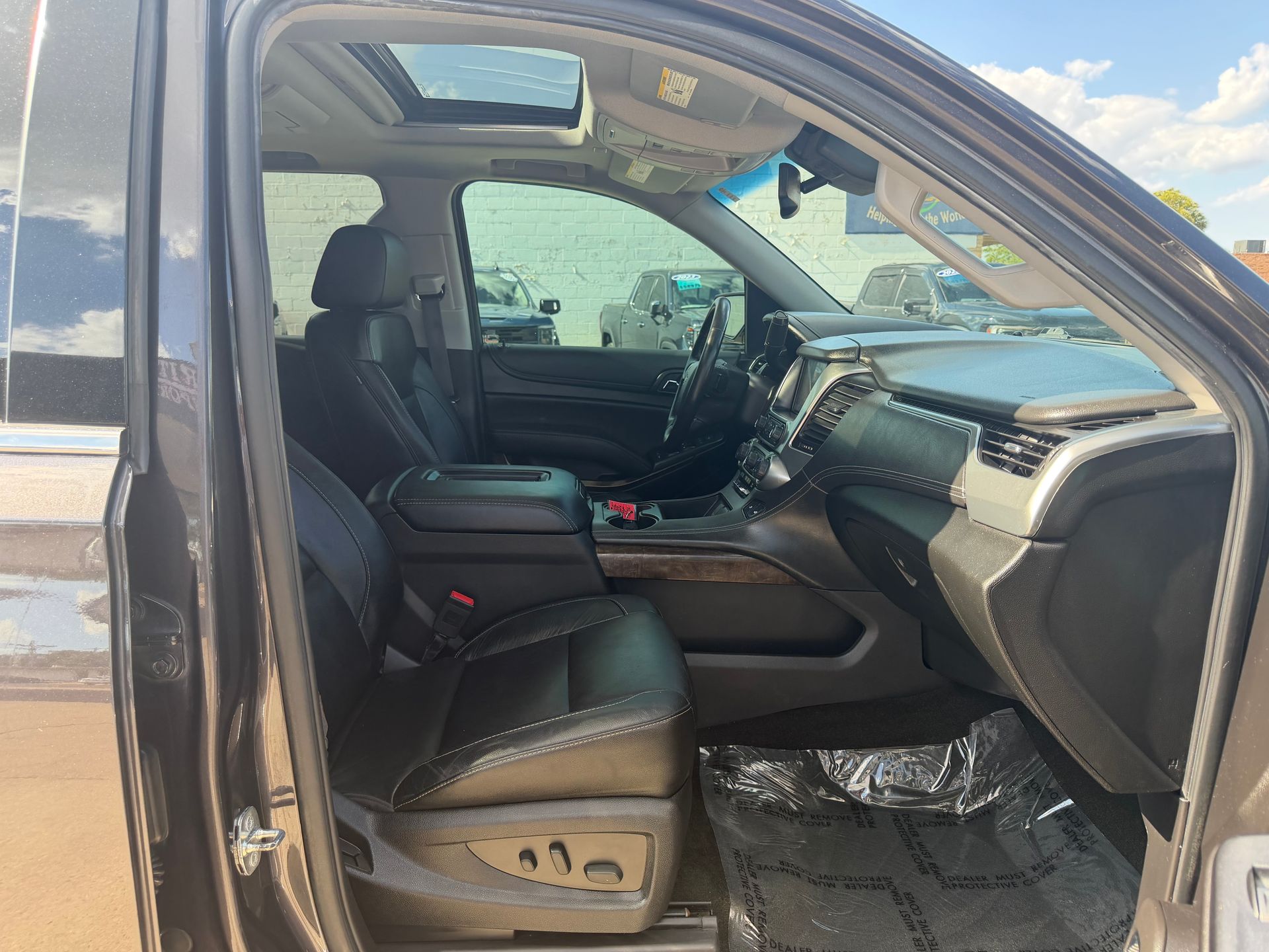 Black pickup truck interior with open rear door, showing black leather seats and dashboard