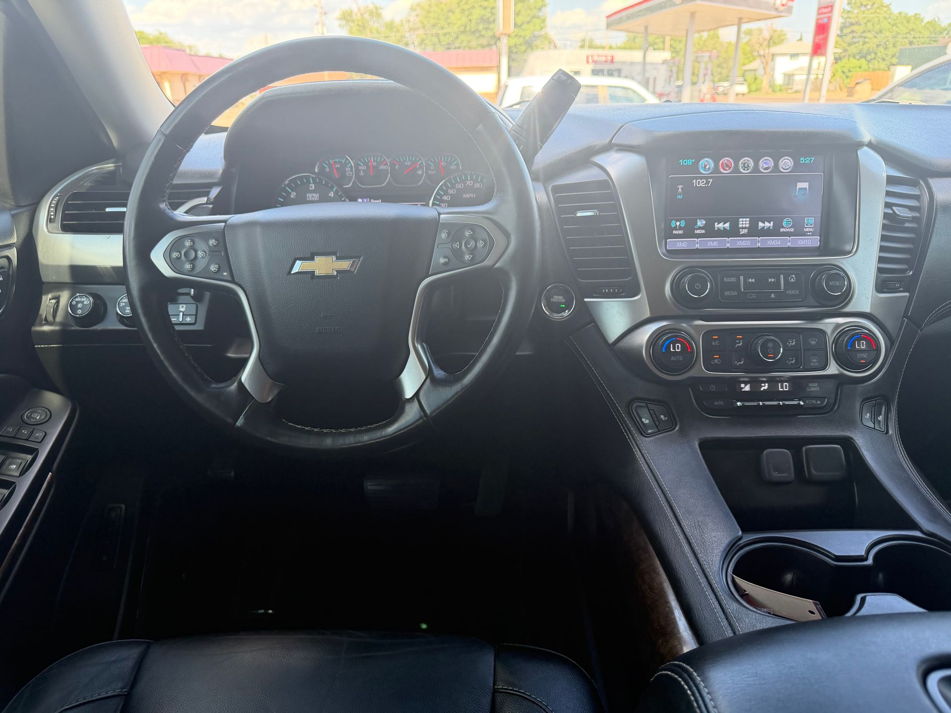 Chevrolet car interior with steering wheel, dashboard, center touchscreen, and front cup holders