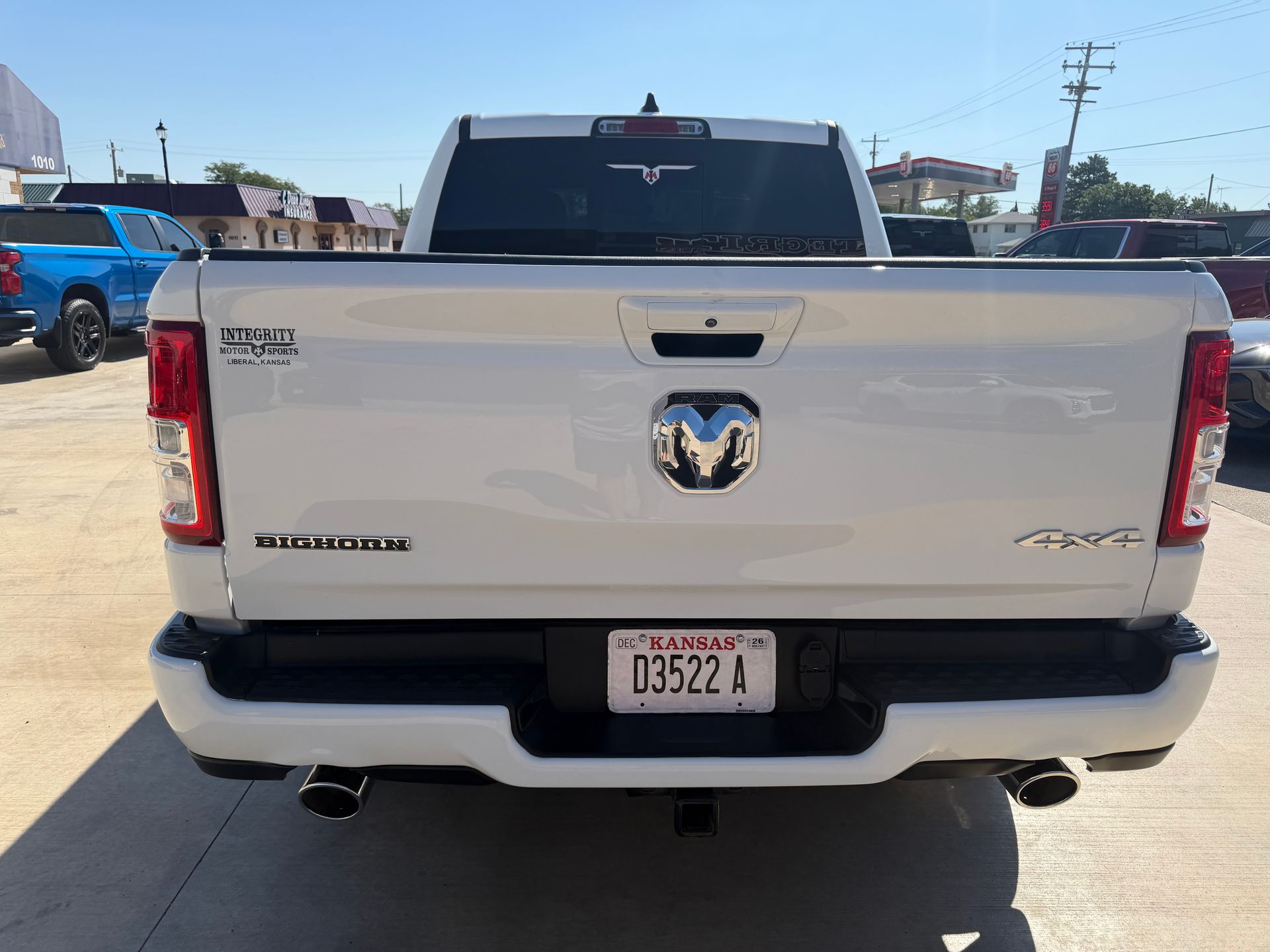Rear view of a white Ram 1500 pickup truck in a parking lot, with a visible license plate.