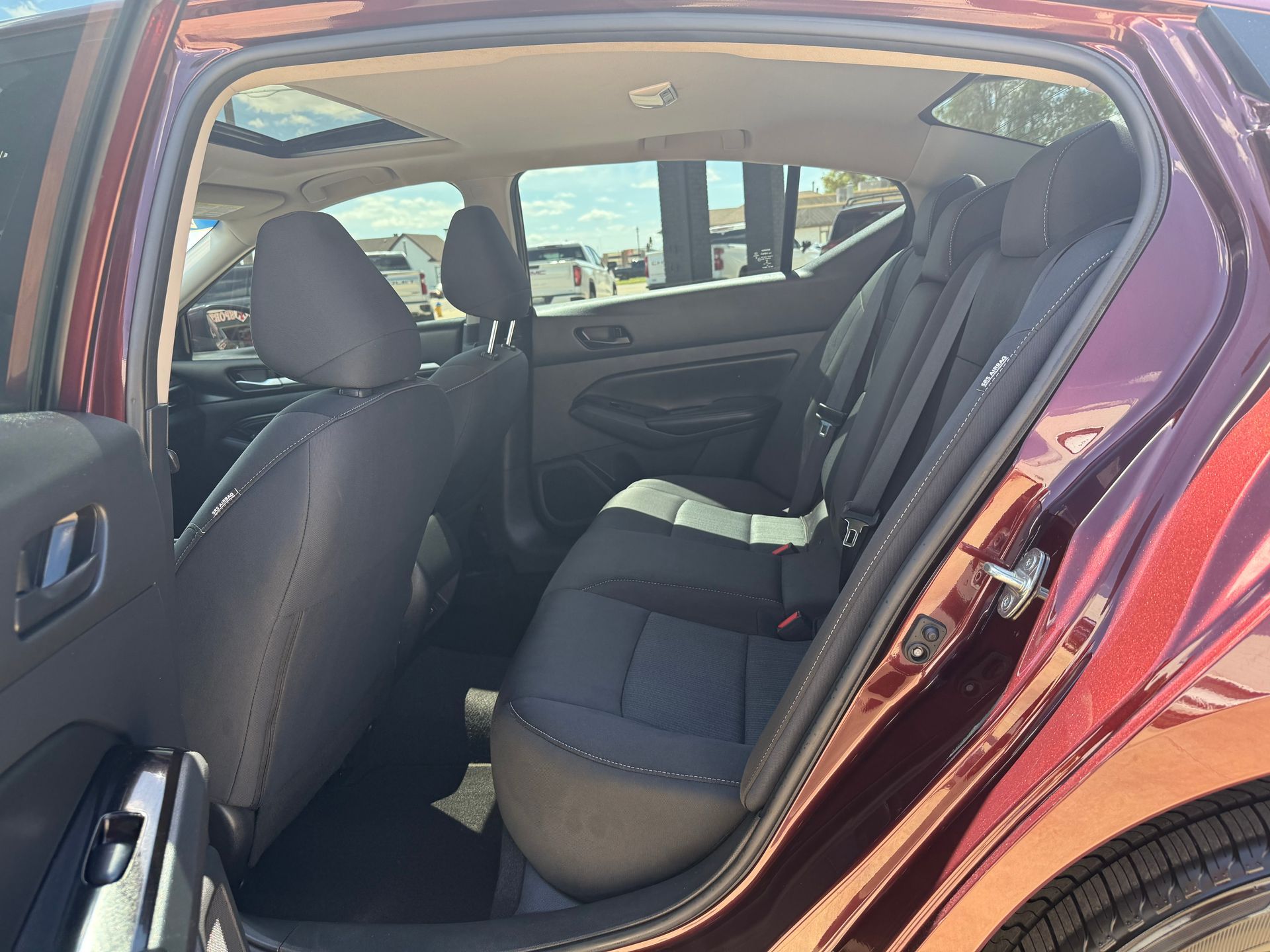 Interior of a red car with black seats; sunroof visible.