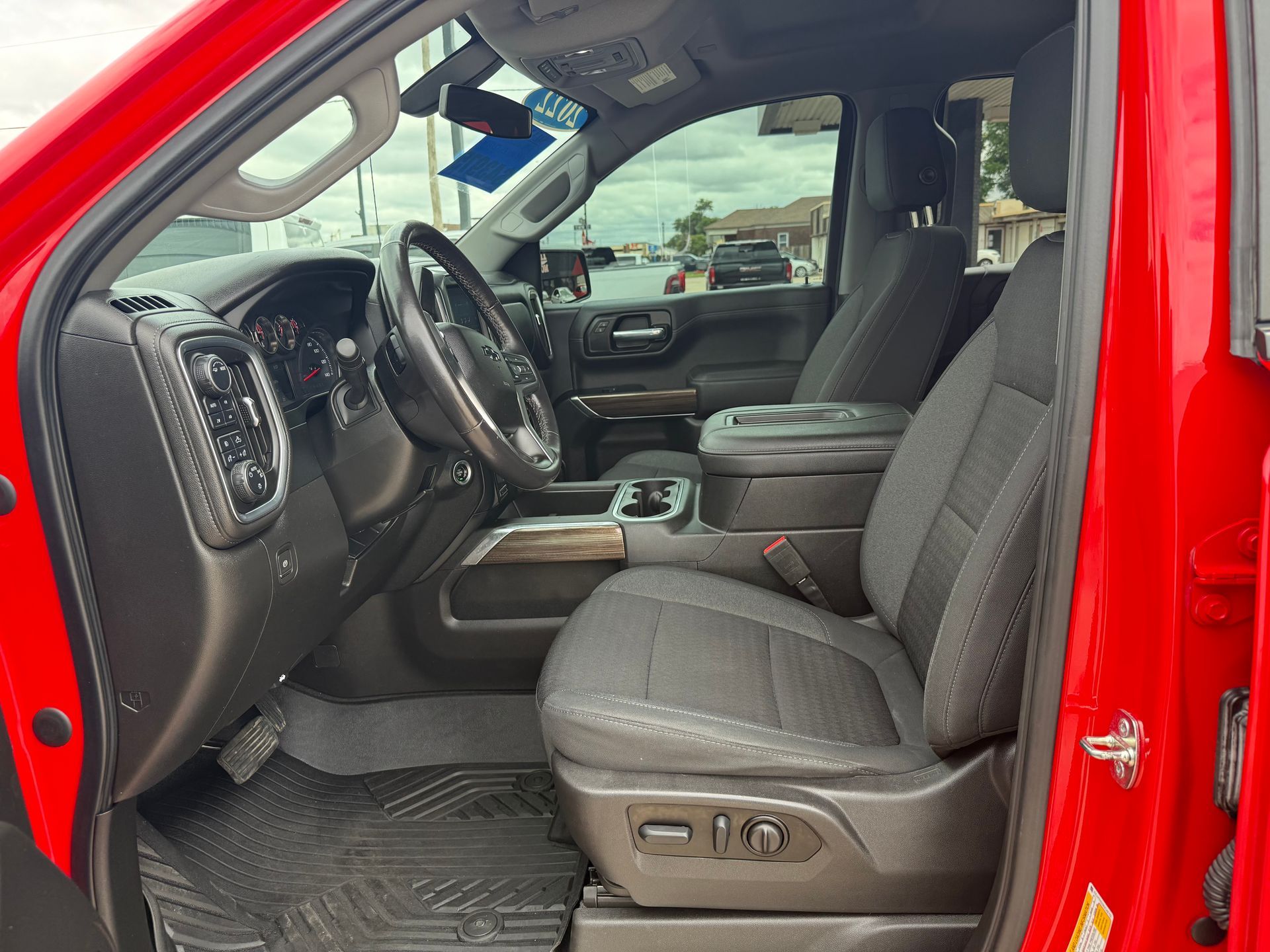 Red truck interior: driver's seat, steering wheel, center console, and dashboard visible.