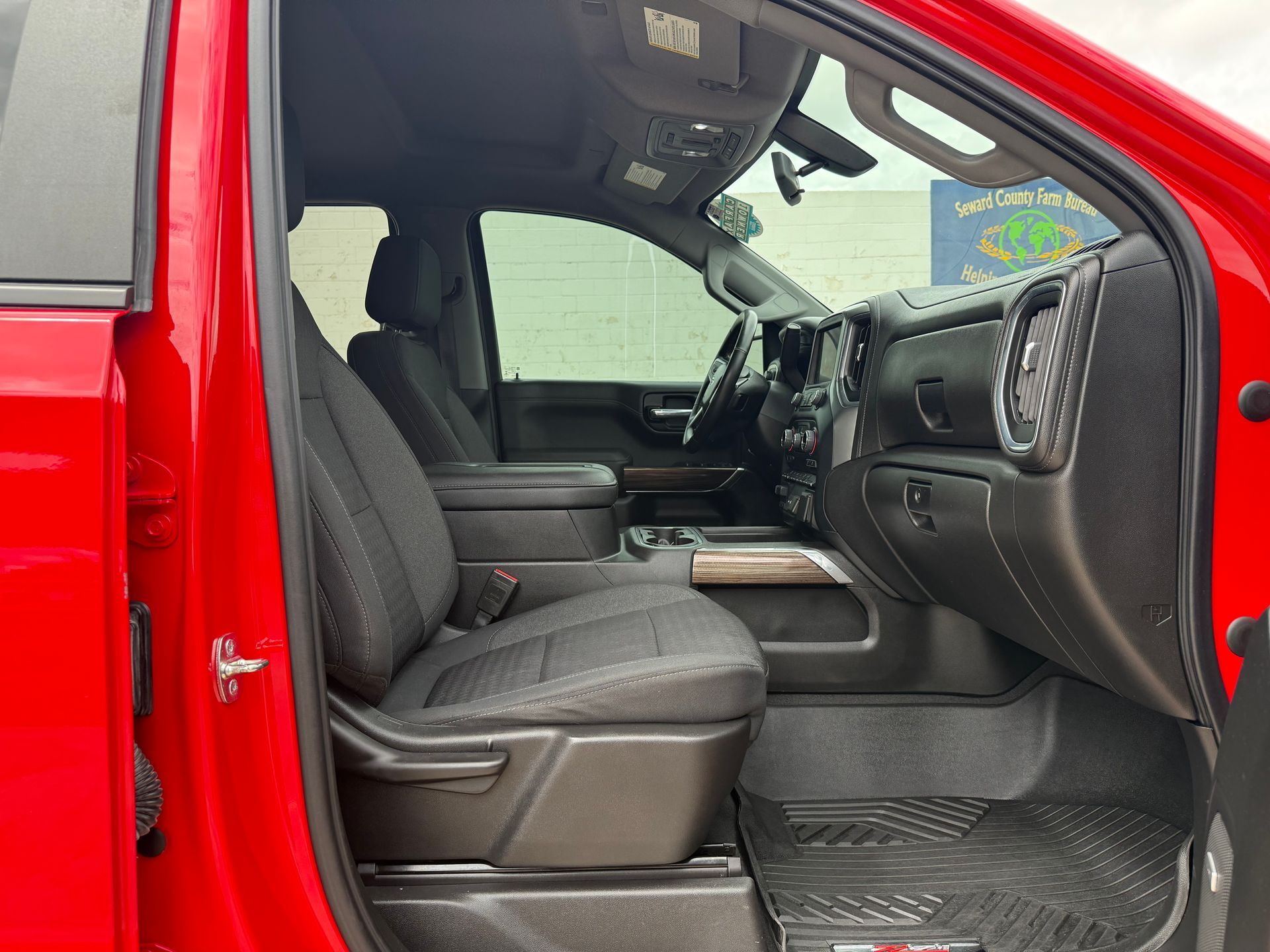 Red truck interior with black seats and dashboard, side view.
