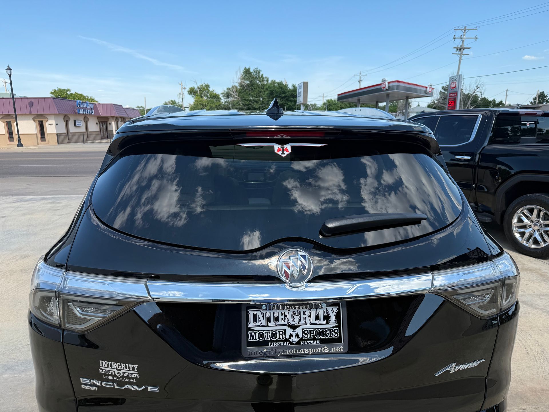 Black Buick SUV parked in front of a building; license plate reads 