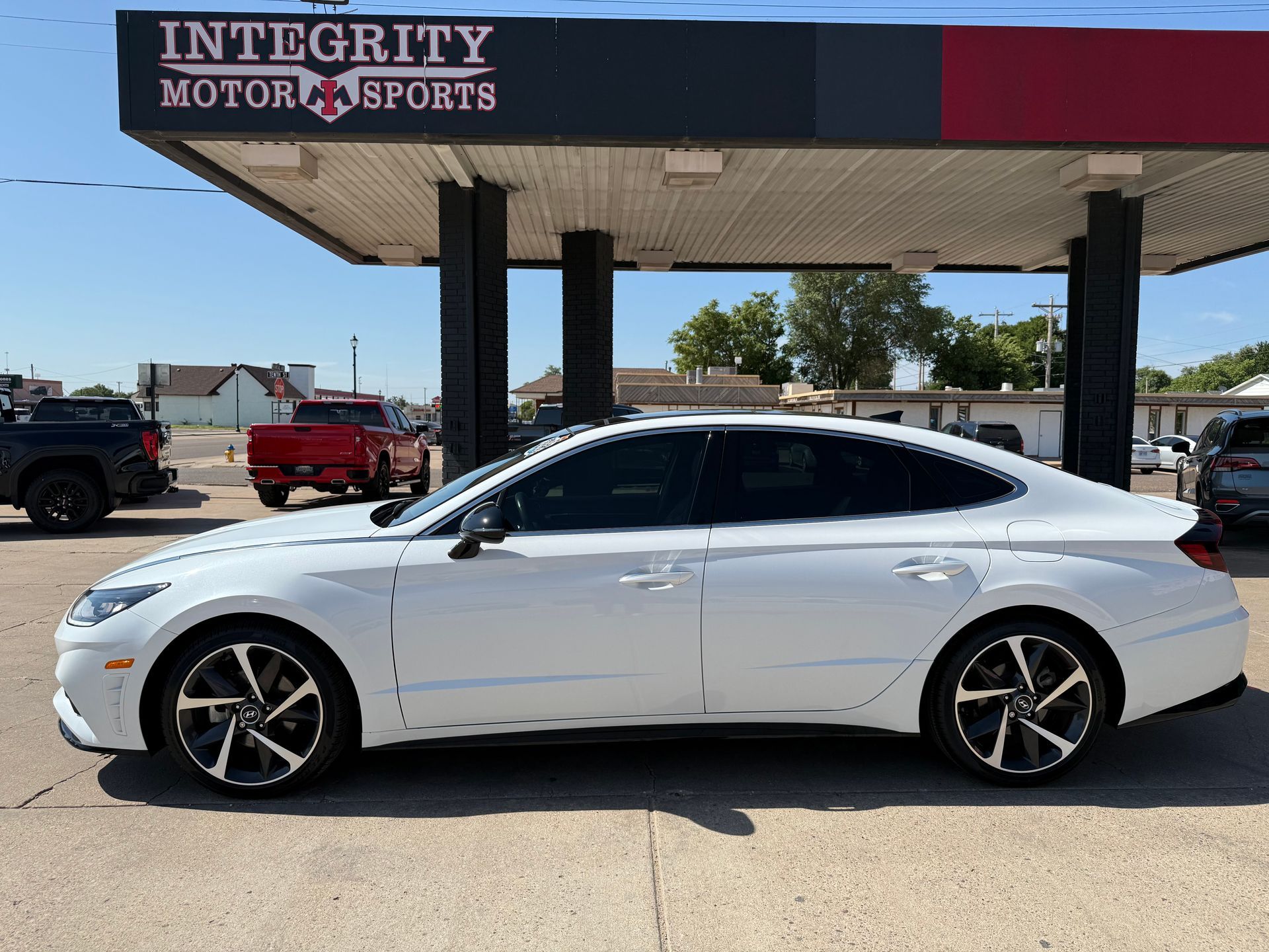 White sedan parked outside Integrity Motor Sports.