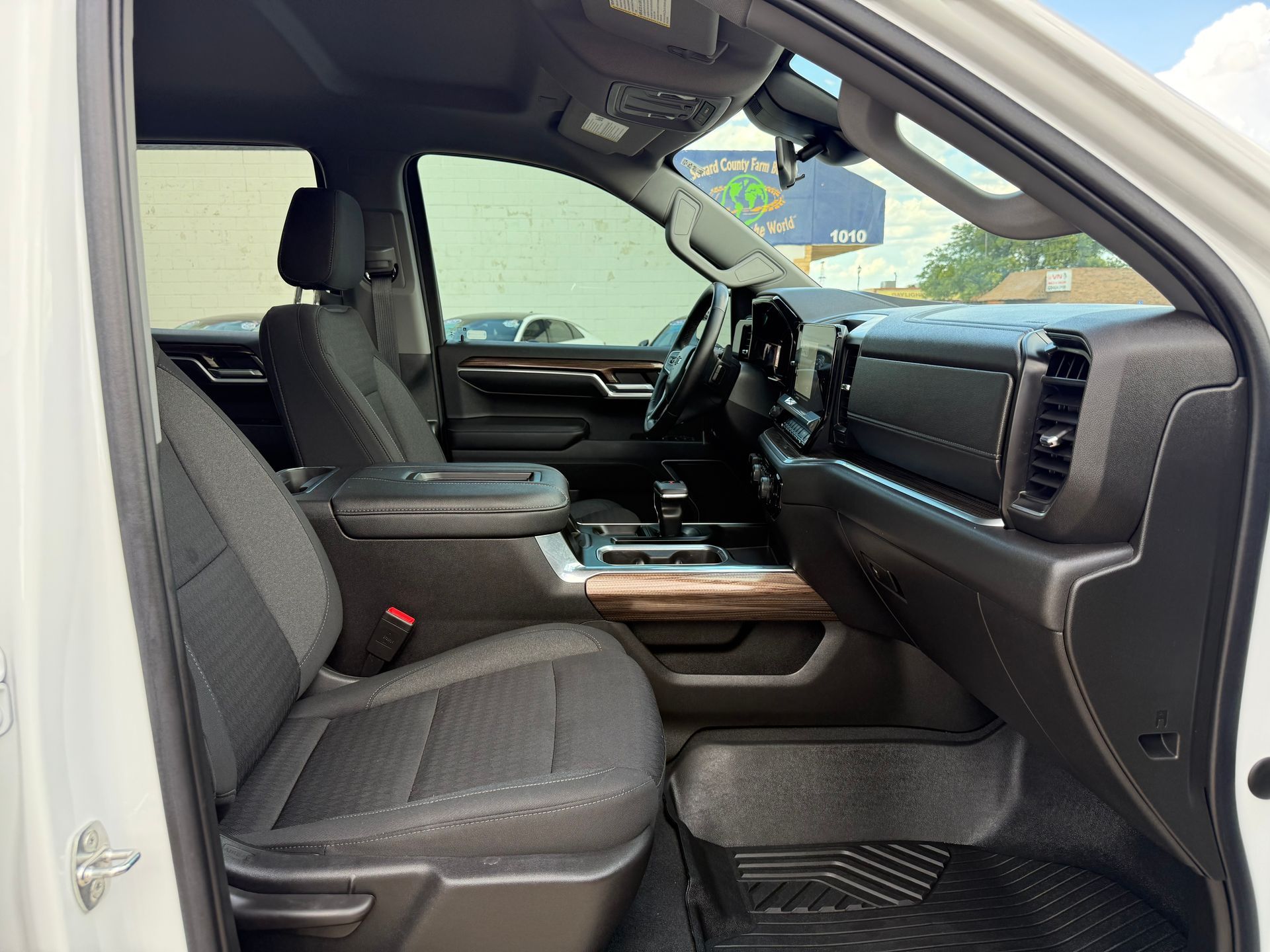 Interior of a white truck, showing the front seats, dashboard, and steering wheel.