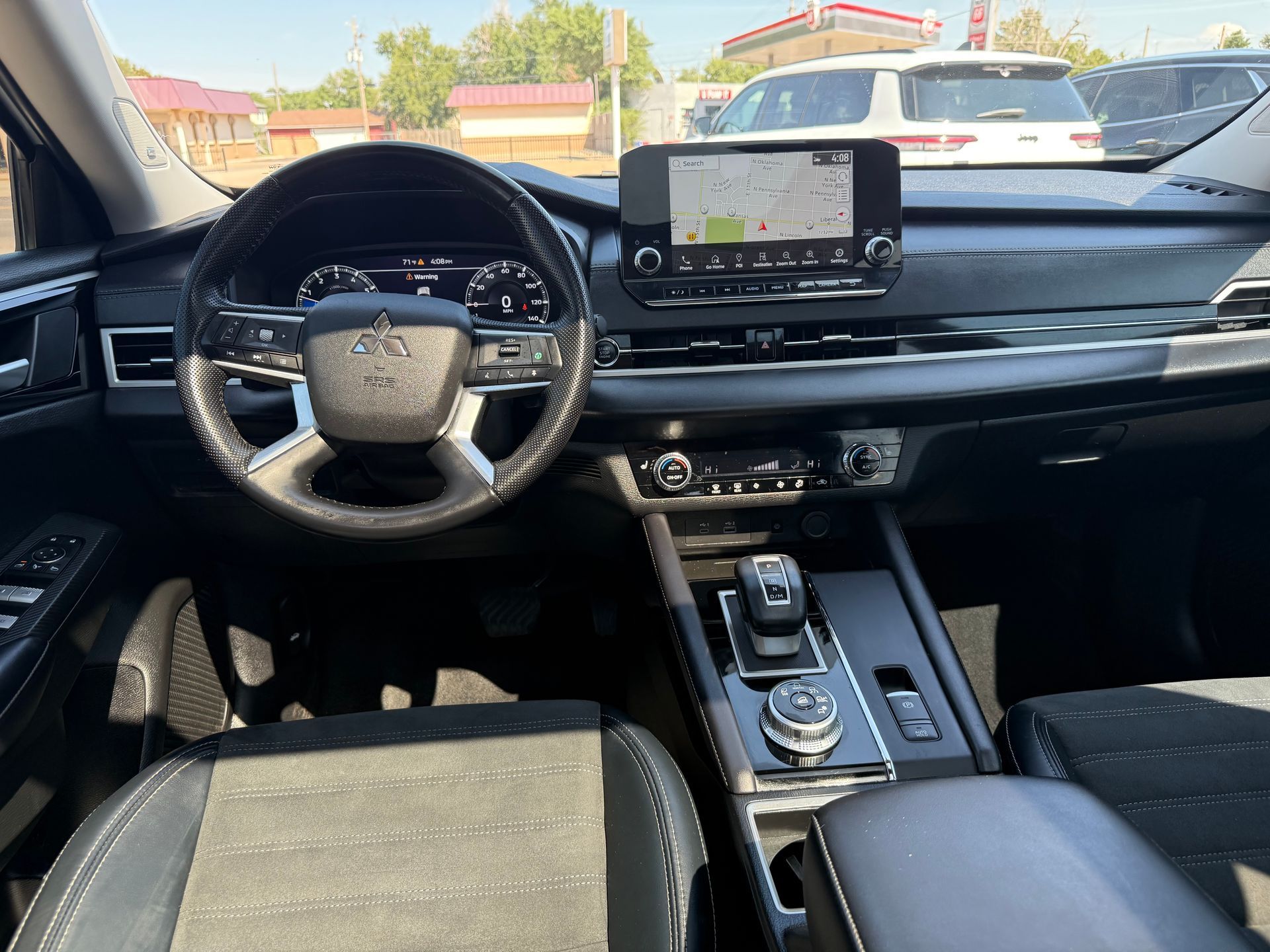 Interior of a car dashboard with steering wheel, digital display, and center console.