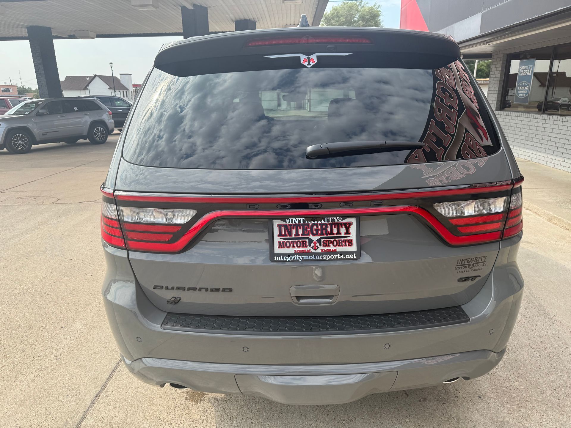 Rear view of a gray Dodge Durango SUV with red taillights, license plate visible.