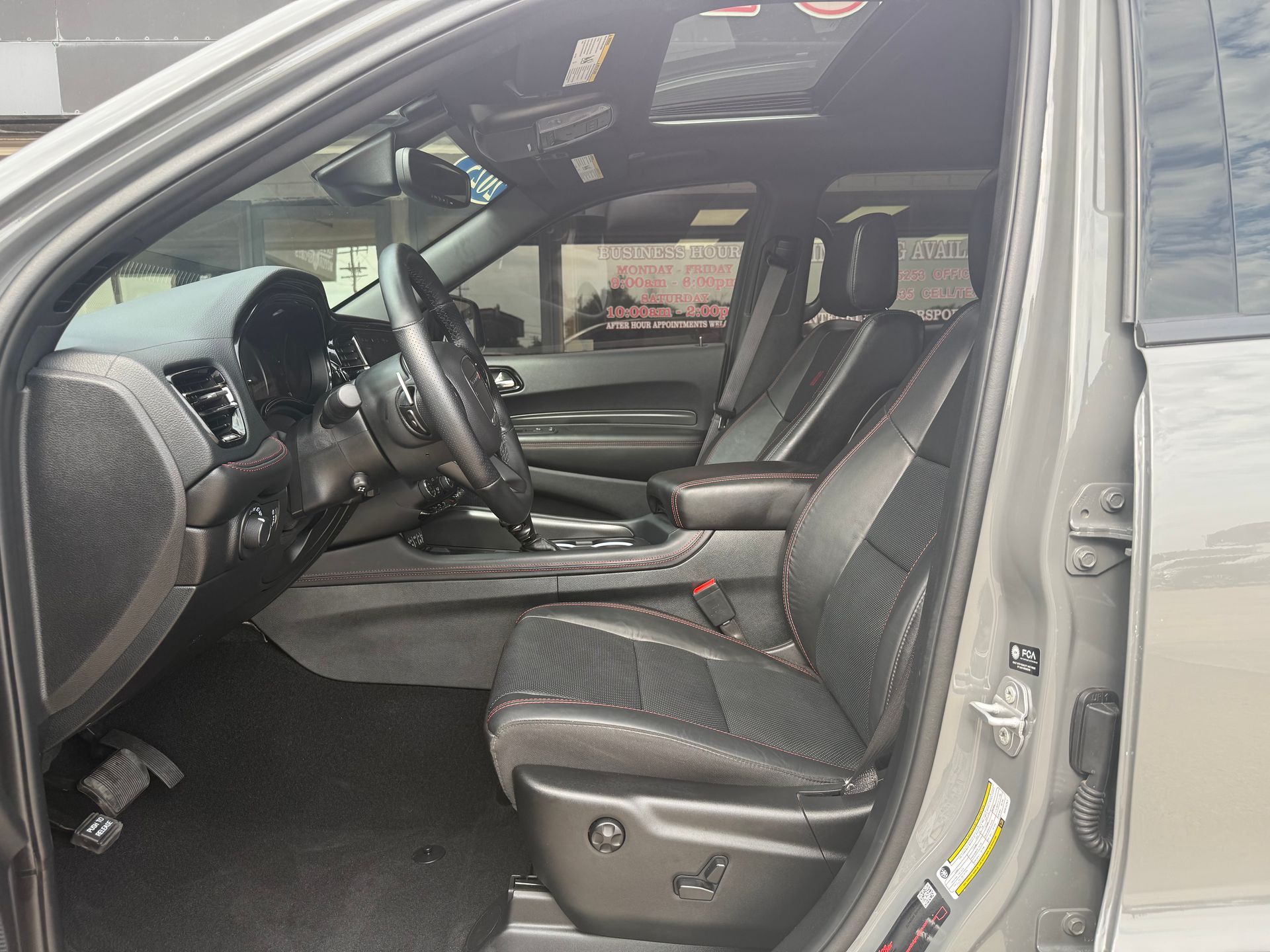 Interior view of a gray Dodge Durango with black leather seats and a panoramic sunroof.