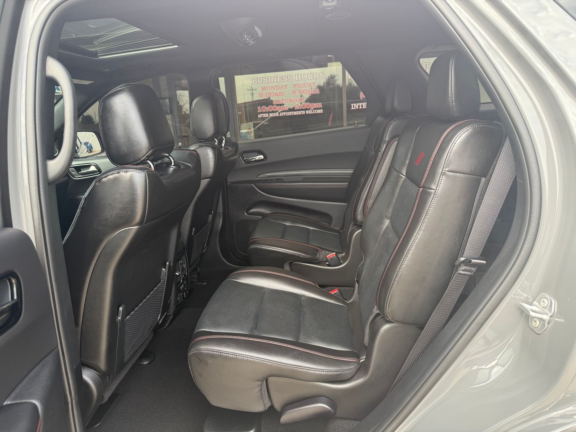 Interior of a gray Dodge Durango SUV. Black leather seats with red stitching are visible.