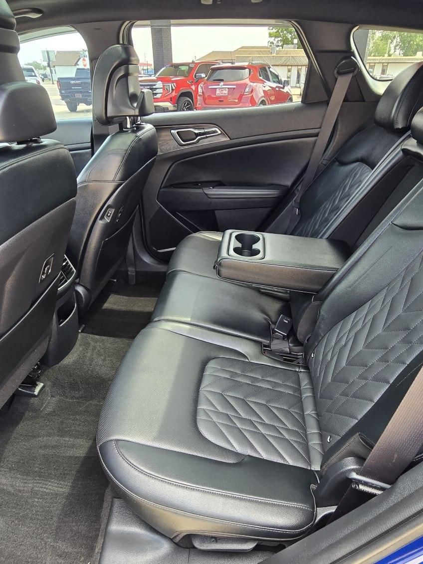 Black leather car back seat with quilted upholstery and fold-down center armrest