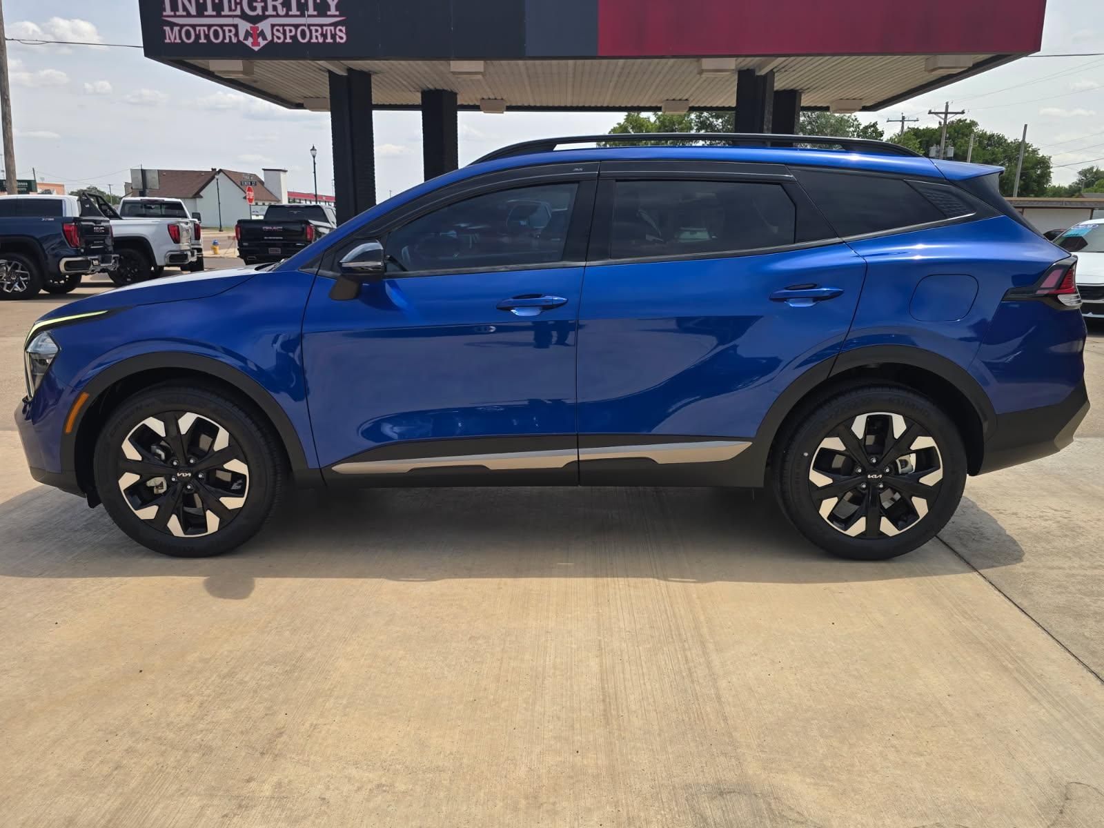 Blue SUV parked on a lot, side view