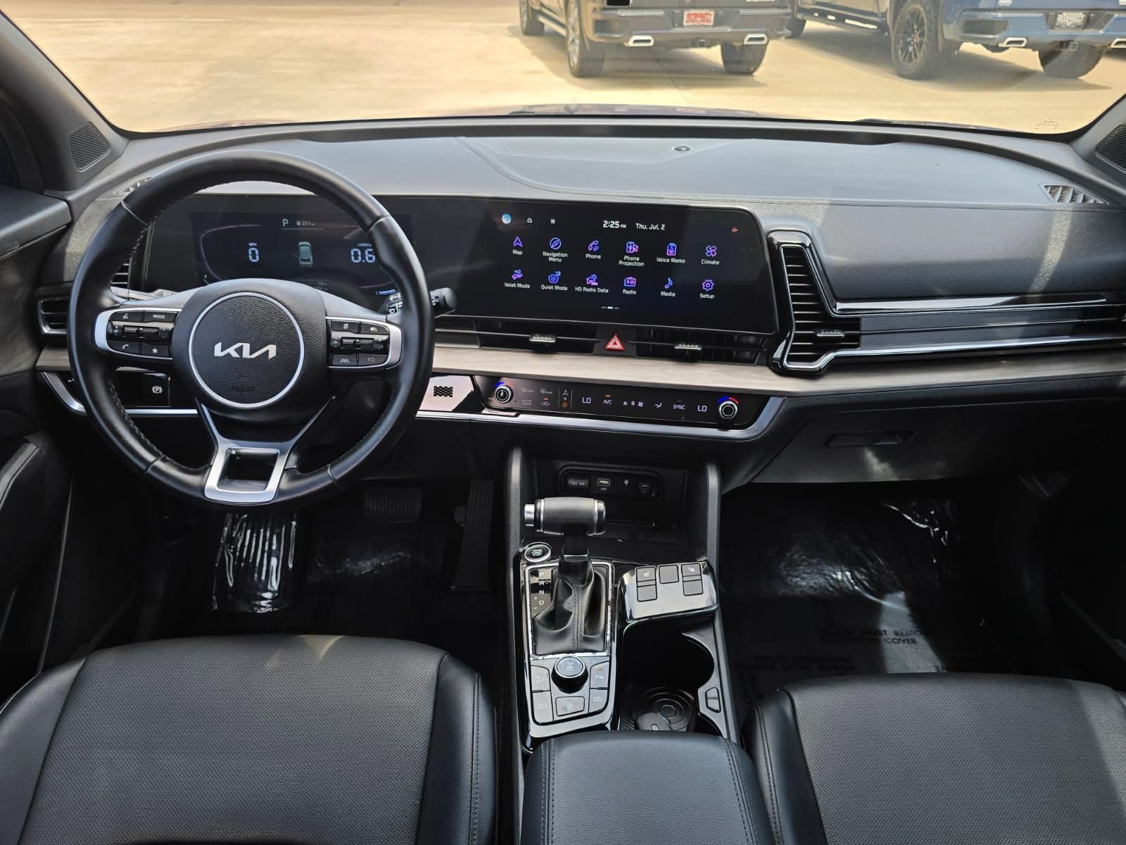 Kia car interior with steering wheel, digital dashboard, and center console in a parked vehicle