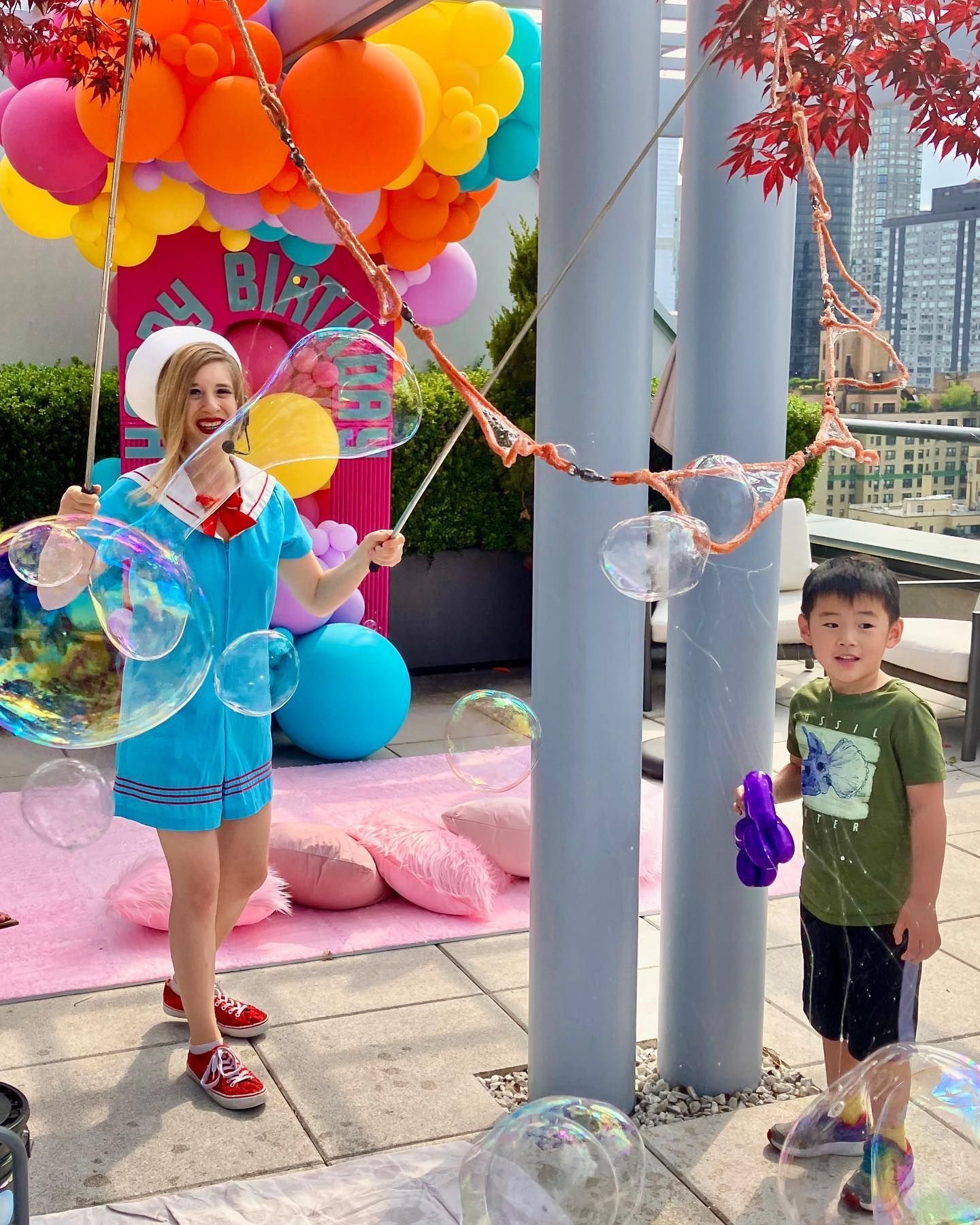 A woman is blowing soap bubbles next to a boy.
