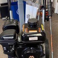 Close-up of a black and orange road-marking paint machine.