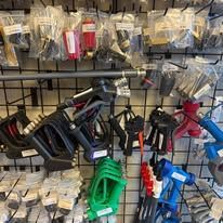 Rows of tools including sprayers, hoses, and attachments hanging on metal racks.