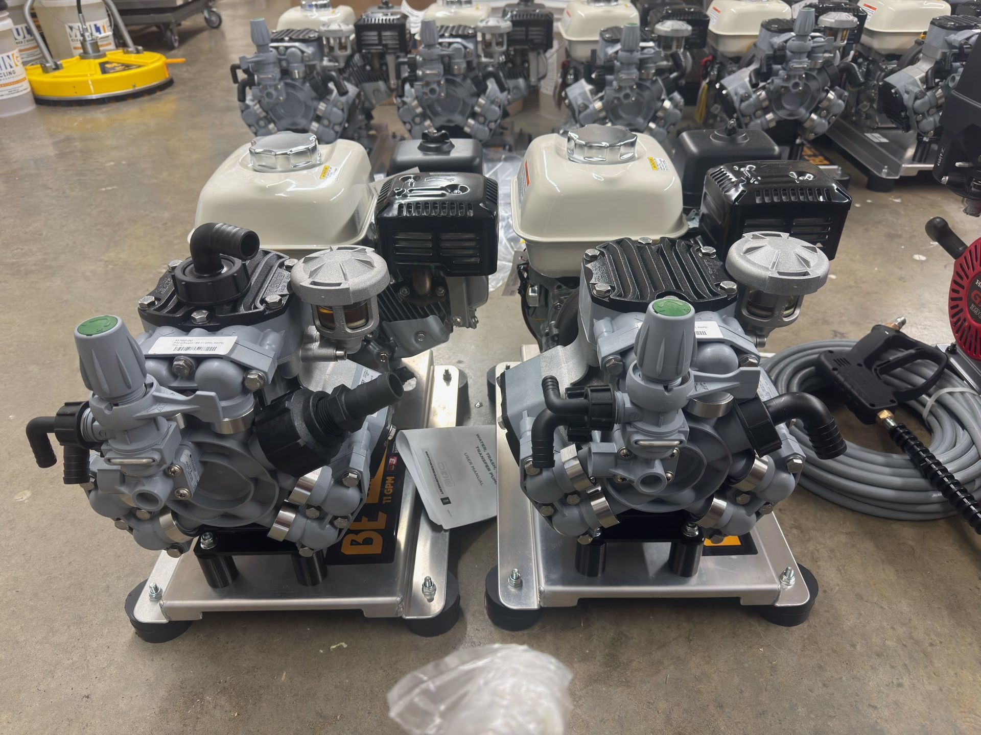 Several industrial pressure washers on a floor.
