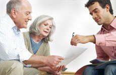 A-man-explaining-paperwork-to-old-couple