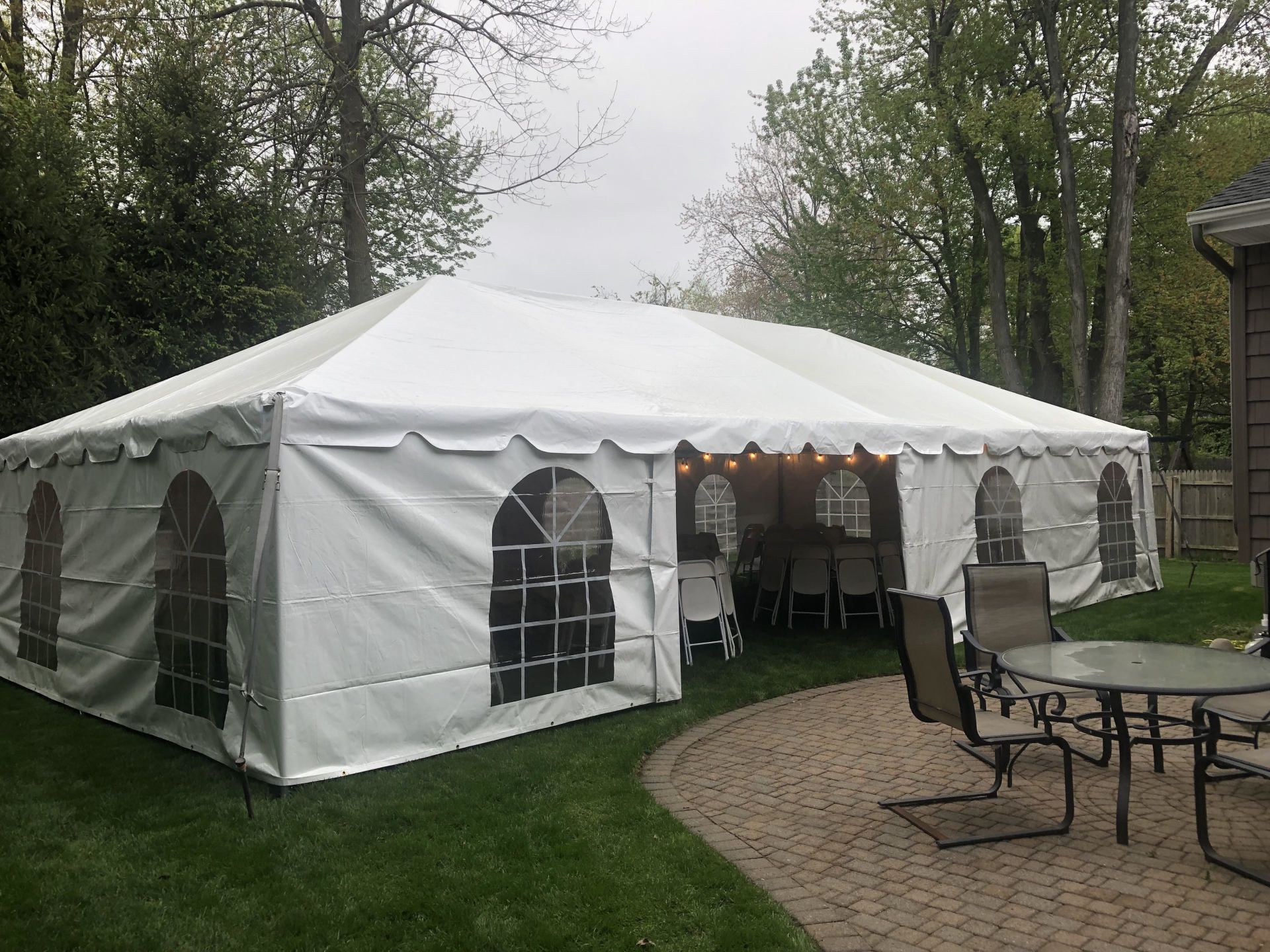 a white tent with chairs and tables in the grass