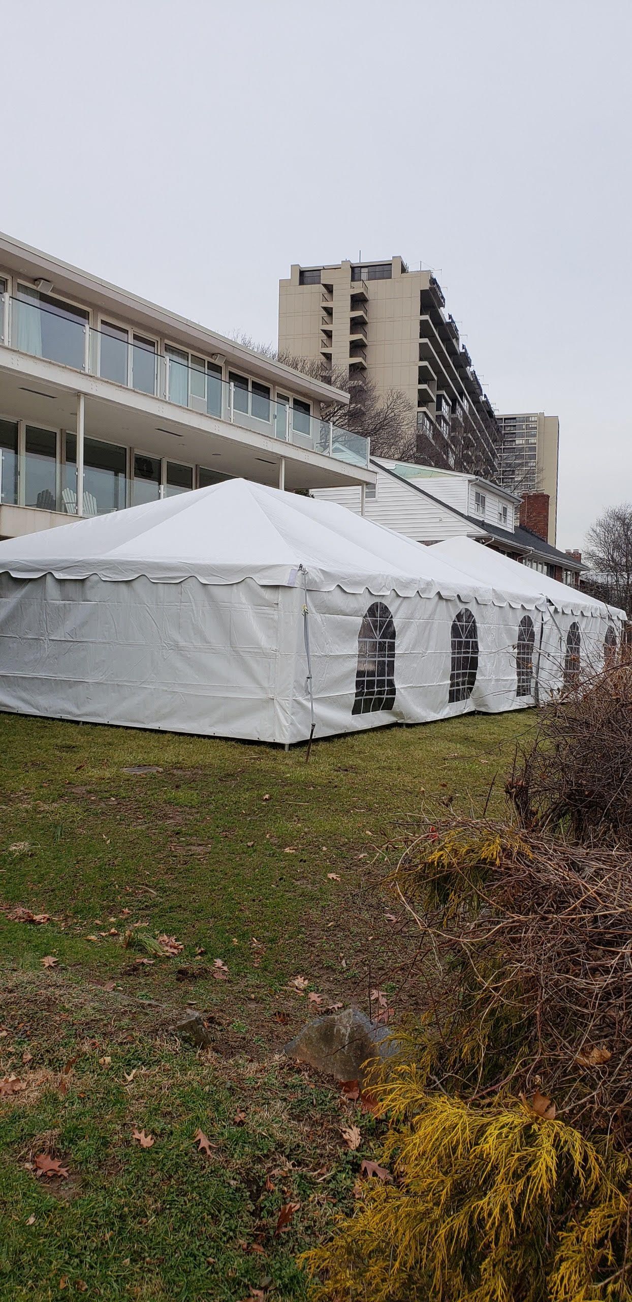 a white tent with windows in front of a building