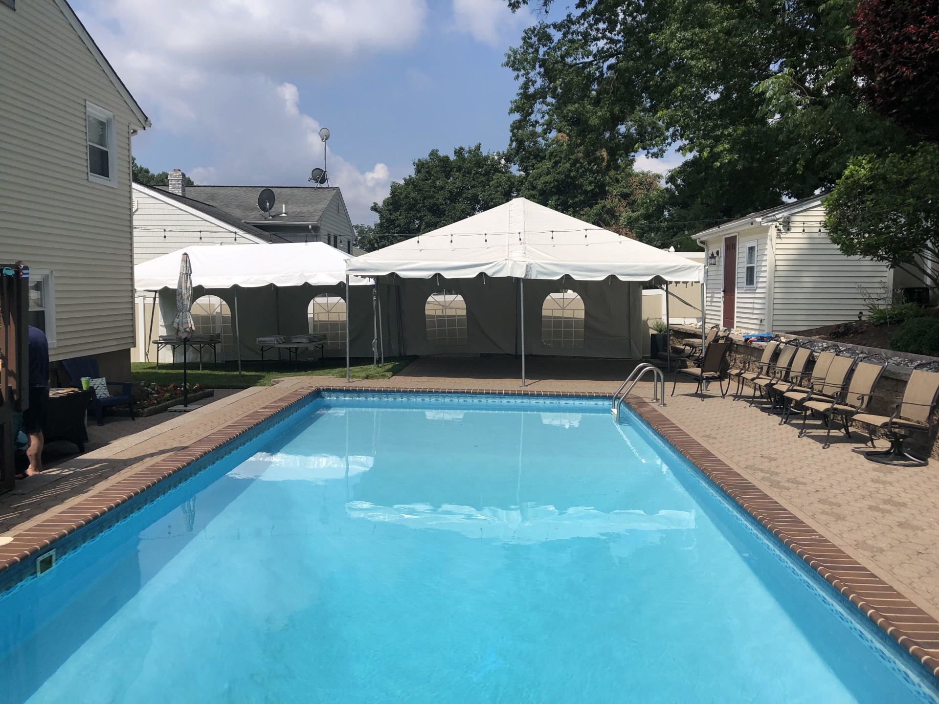 a swimming pool with chairs and a tent