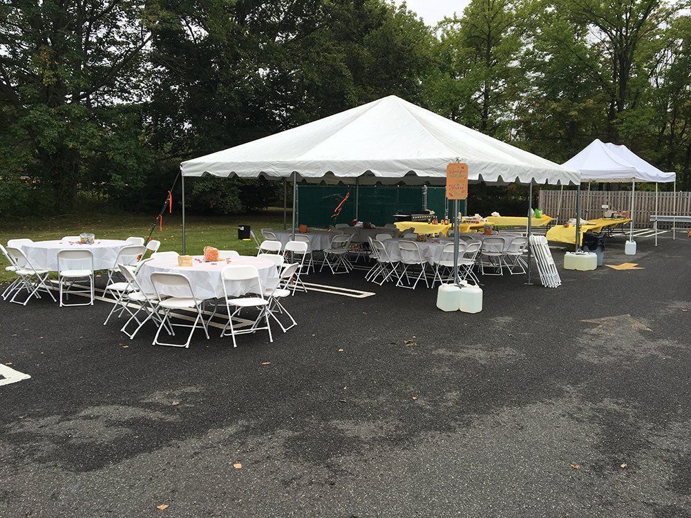 a white tent with tables and chairs