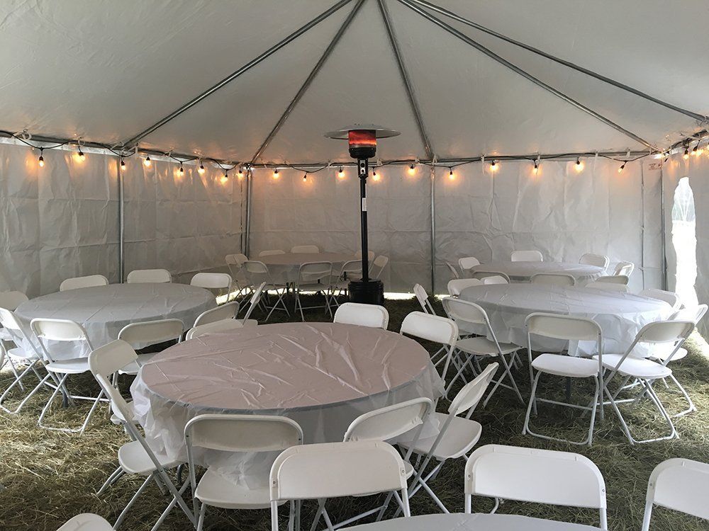 a white tent with tables and chairs