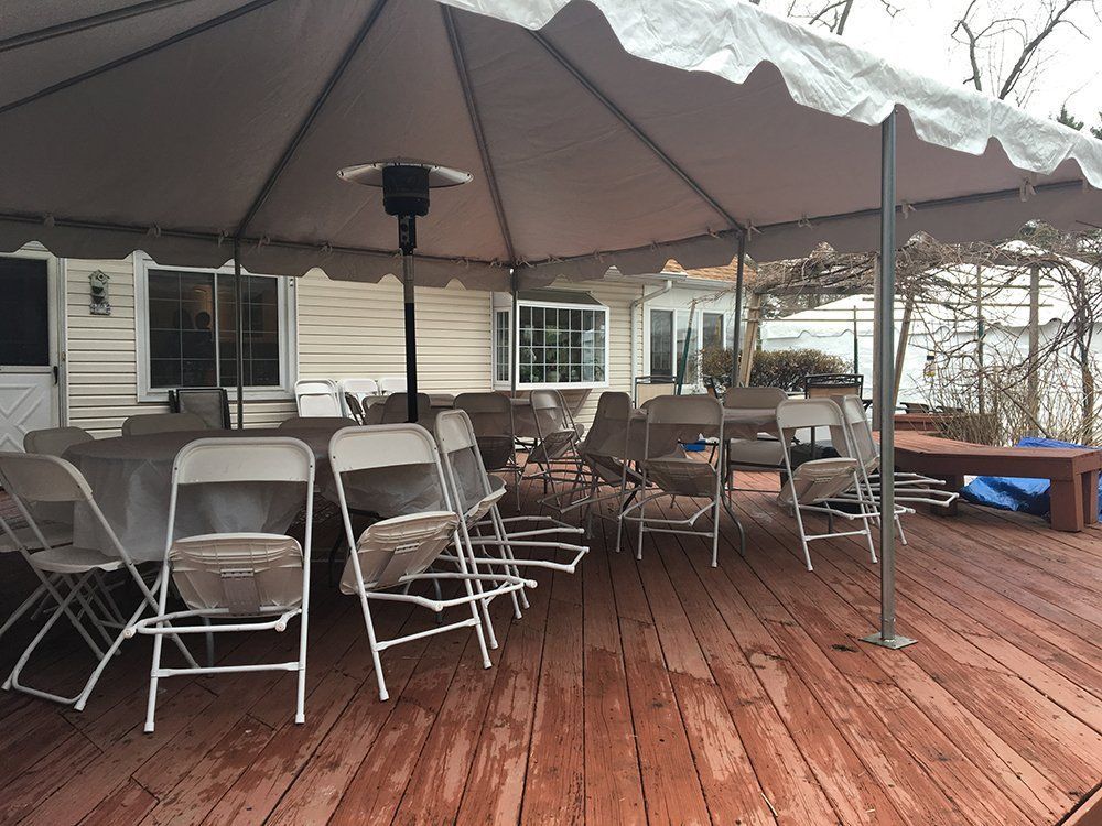 a tent with chairs and tables on a deck