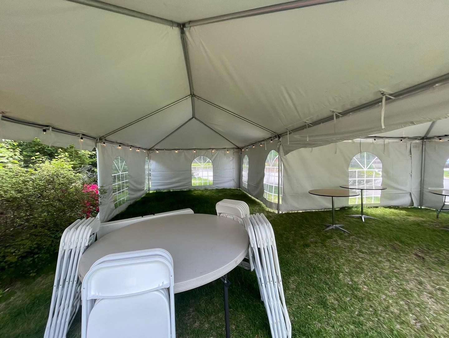 a white tent with a table and chairs