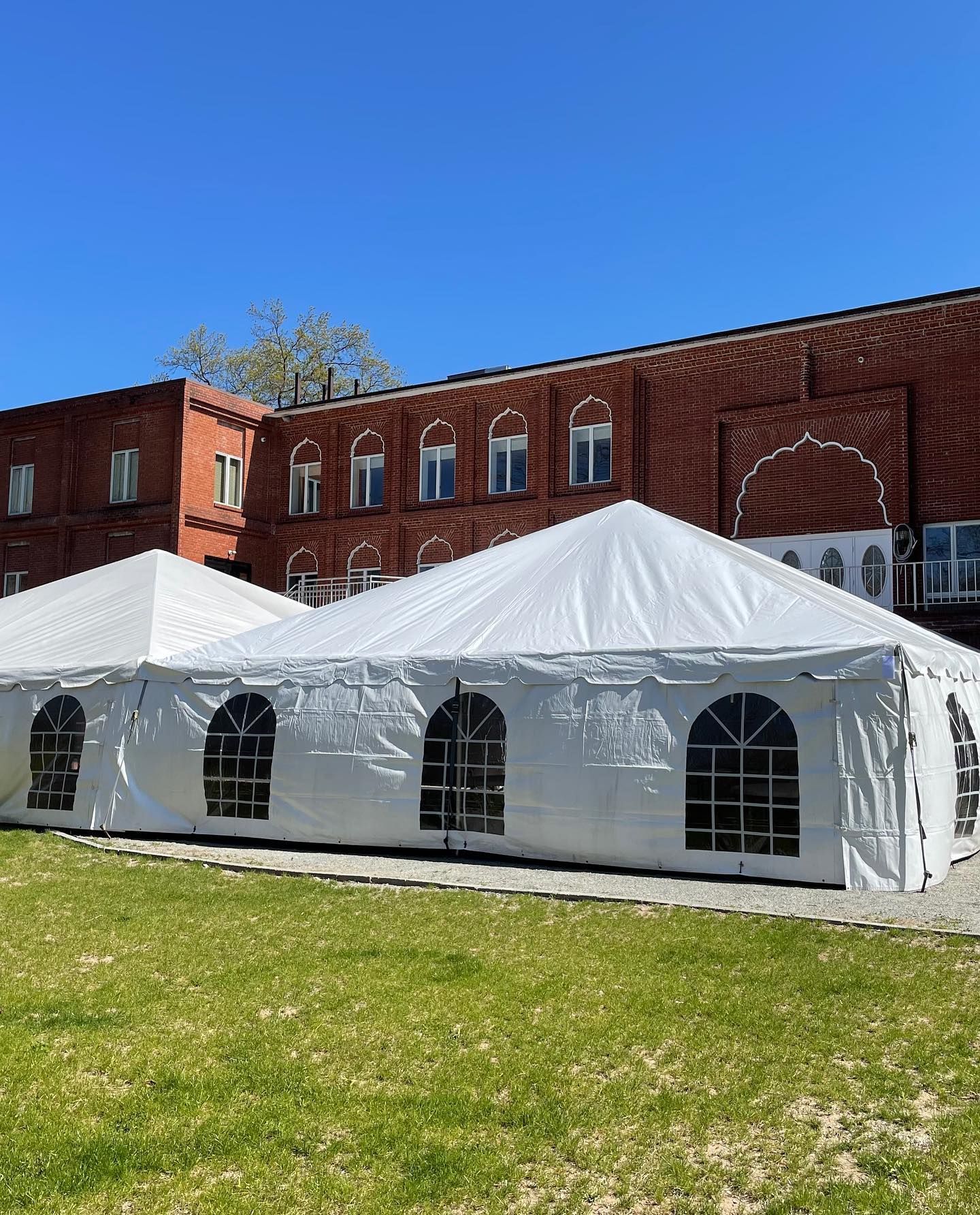 a white tent in front of a brick building