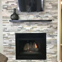A fireplace with a brick wall and a flat screen tv above it.