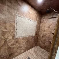 A bathroom with a walk in shower and a tiled wall.
