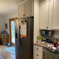 A kitchen with a refrigerator , dishwasher , and cabinets.