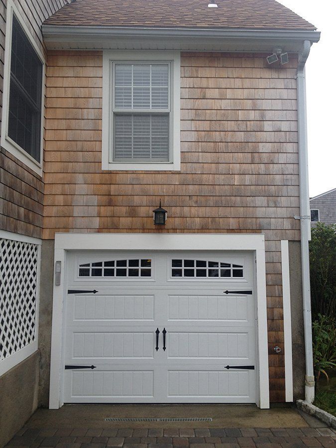 A white garage door is on the side of a house
