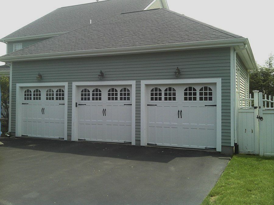 Three white garage doors with the letter m on them