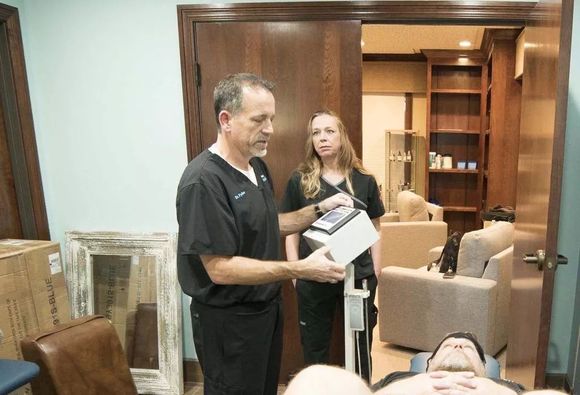 A man and a woman are standing next to each other in a room.