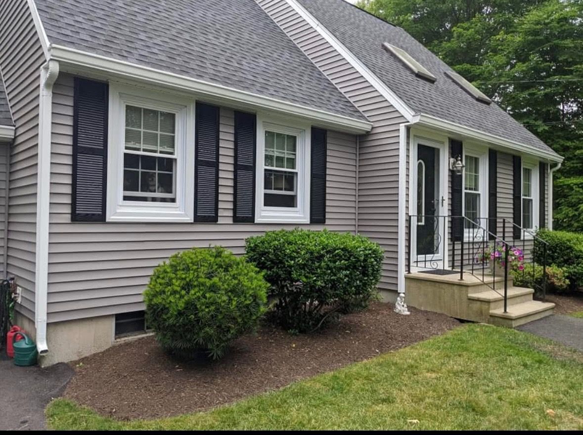 A house with a gray siding and black shutters