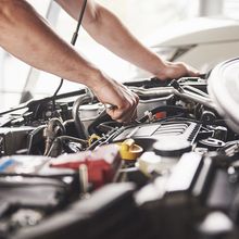 A man is working on the engine of a car.