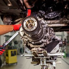 A man is working on a car engine in a garage.