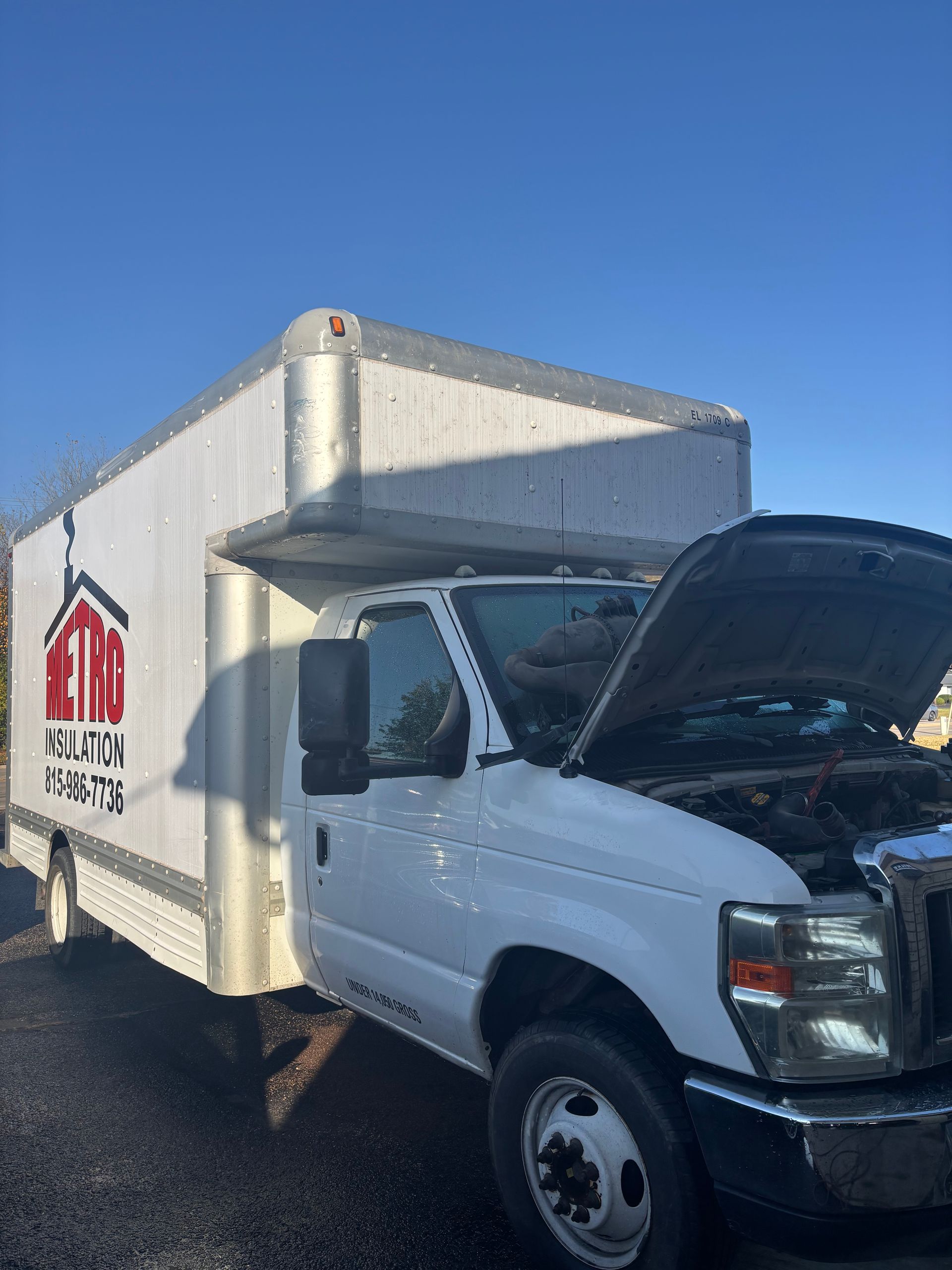 A white truck with the hood open is parked on the side of the road.