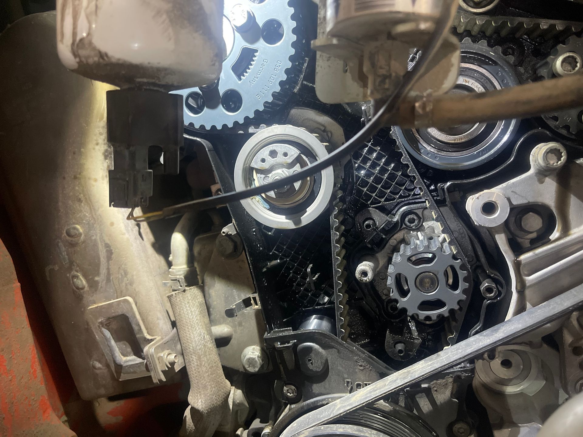 A close up of a car engine with a lot of gears and belts.