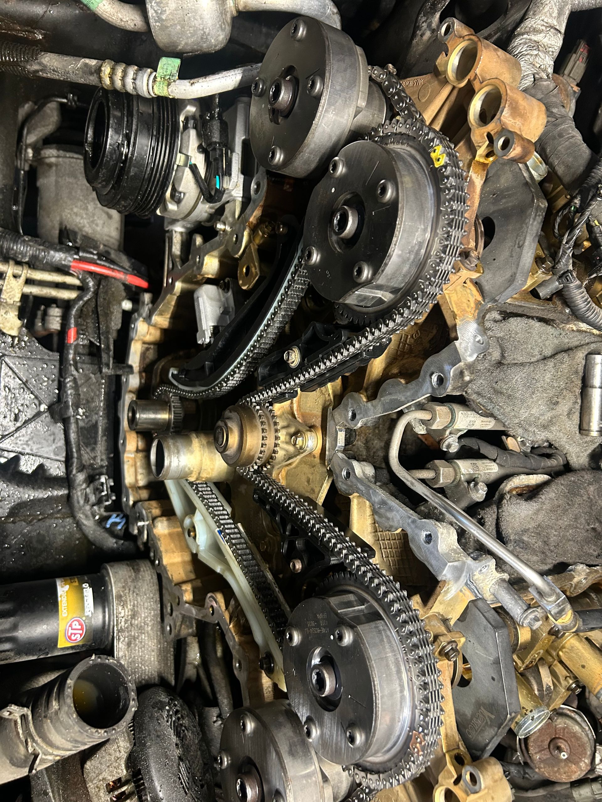 A close up of the inside of a car engine with chains.