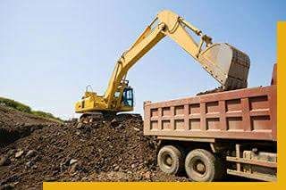 Yellow backhoe and hauling truck