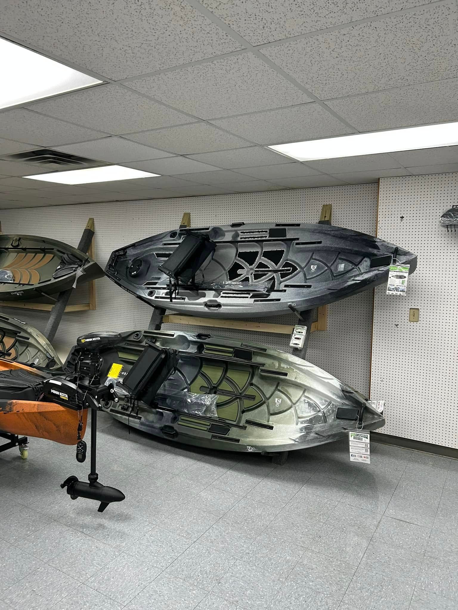 A row of kayaks hanging on a wall in a store.