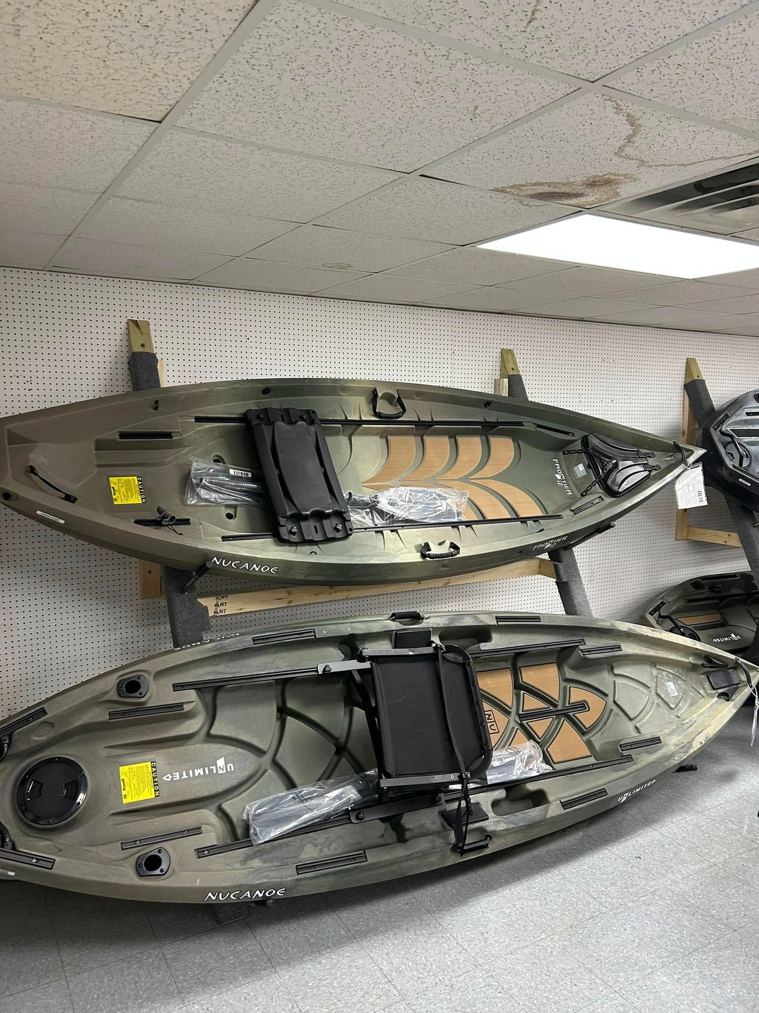 A row of kayaks sitting on top of each other in a room.