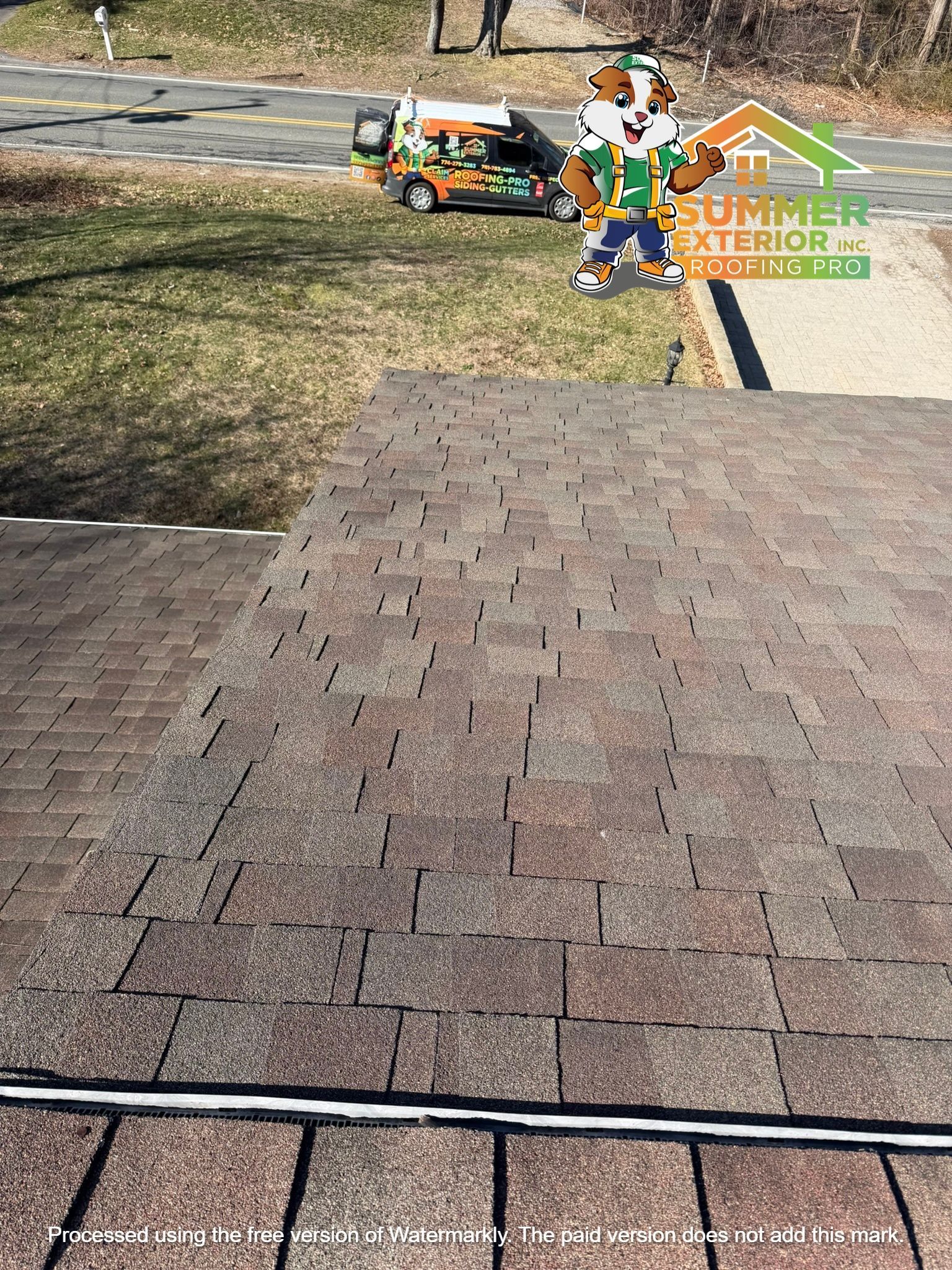 A residential roof installation in progress with a mascot logo in the upper right and a company van parked nearby.