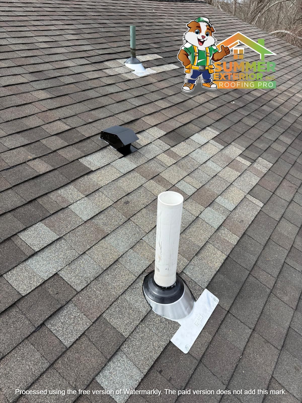 A sloped shingled roof features a white plumbing vent, a black hood vent, and a small metal pipe with a logo sticker.