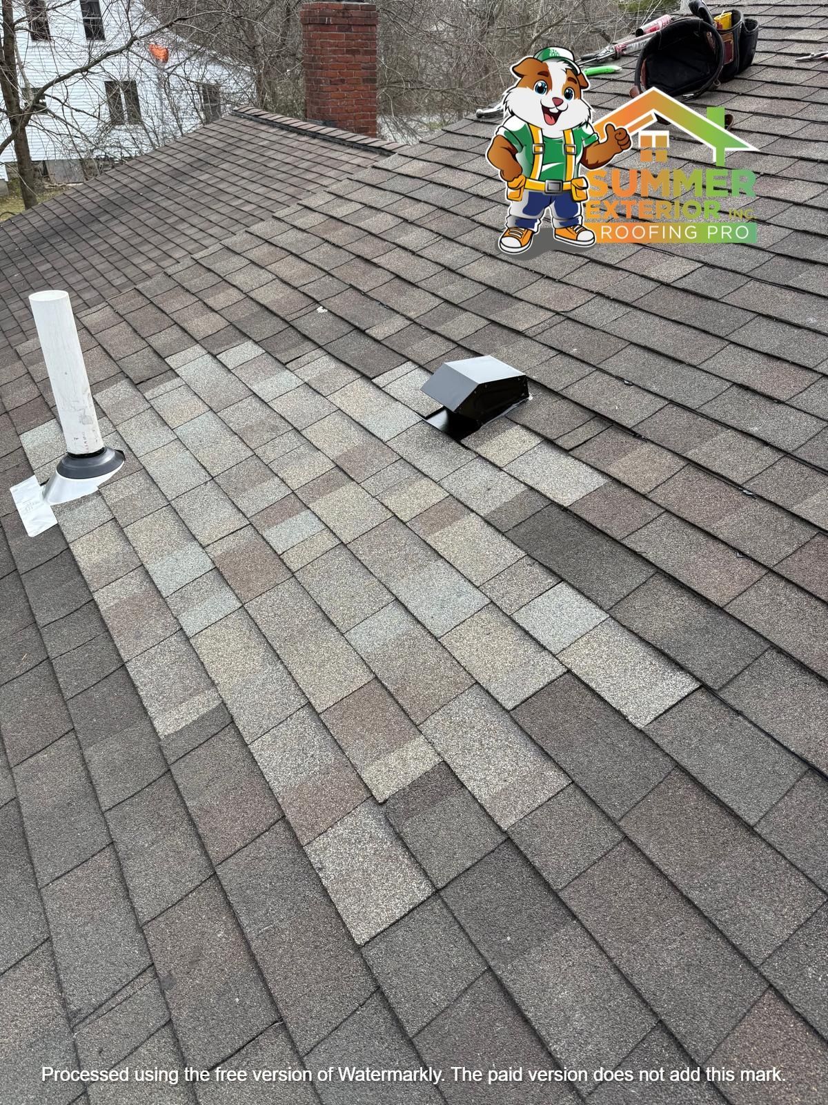 A roof with a patch of lighter-colored shingles around a vent pipe and a vent hood, featuring a cartoon beaver logo.