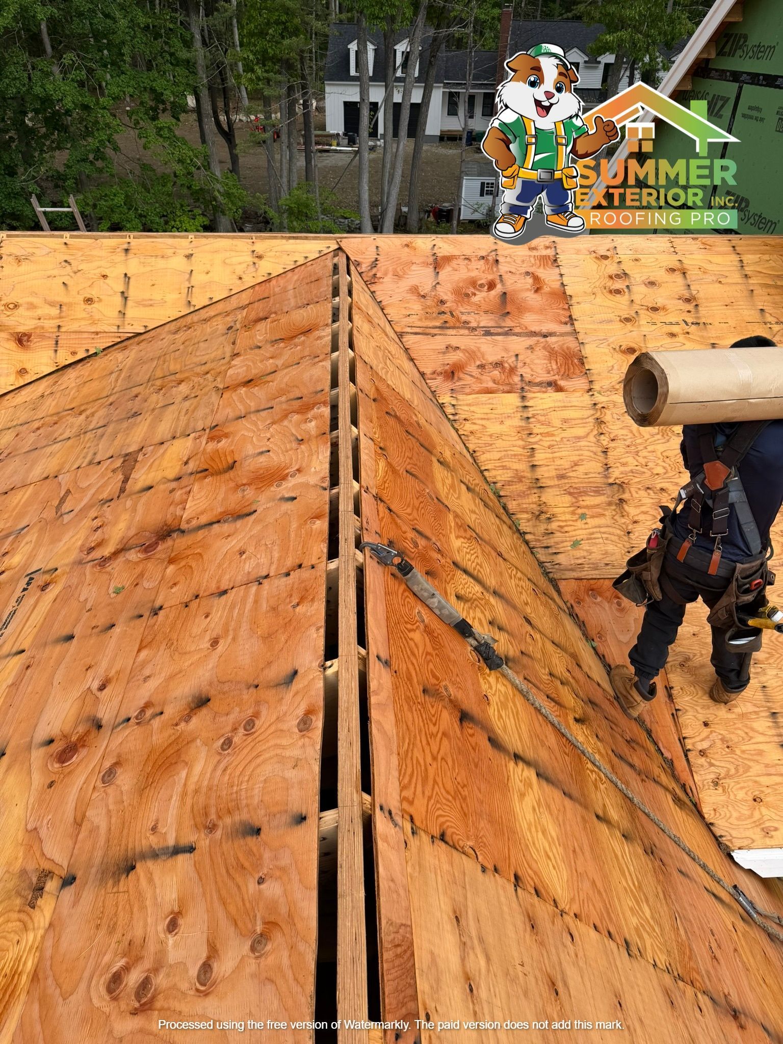 Workers on an orange roof building a wooden ramp at a winter obstacle course.
